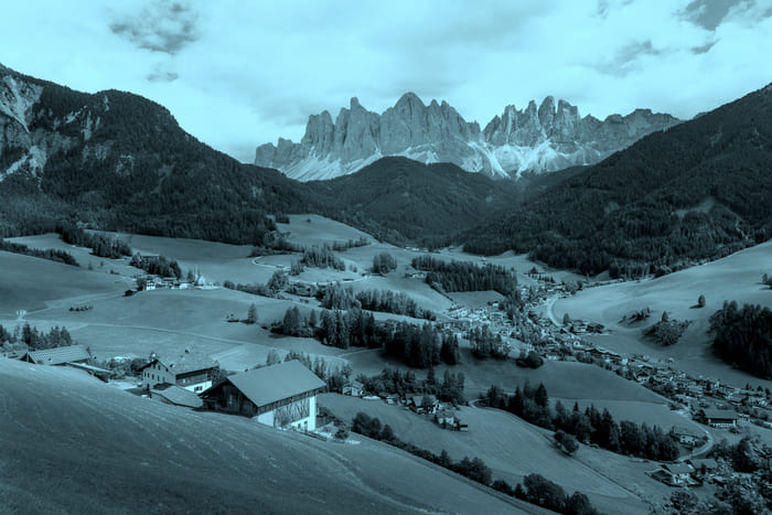 Ein typischer Bergbauernhof in einer österreichischen Gebirgslandschaft – Symbol für die Landwirtschaftsversicherung von RIANEVA, die landwirtschaftliche Gebäude vor Schäden absichert.