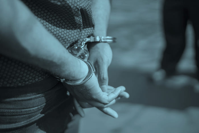 Hände in Handschellen – repräsentiert die RIANEVA private Haftpflichtversicherung und deren Schutz vor rechtlichen und finanziellen Risiken im Alltag.