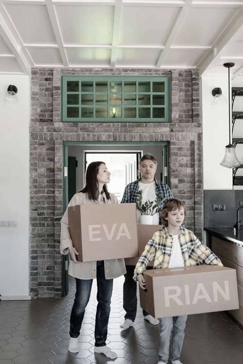 Eine Familie betritt eine Wohnung mit Umzugskartons, auf denen "RIAN" und "EVA" steht – repräsentiert die Abo-Pakete von RIANEVA und flexible Lösungen für ein neues Zuhause.